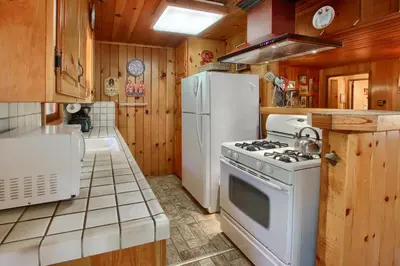 a kitchen with a white stove and a refrigerator at Shangri la-de-da at The Redwoods in Wawona