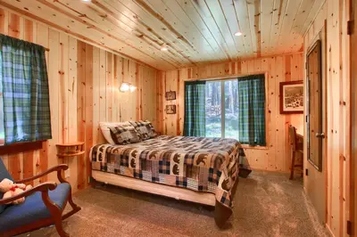 a bedroom with a bed in a wooden cabin at Shangri la-de-da at The Redwoods in Wawona
