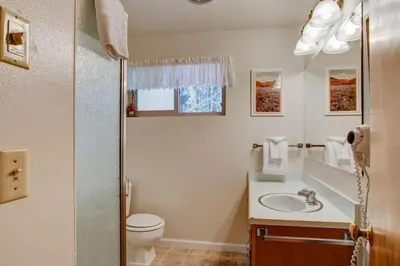 a bathroom with a sink and a toilet and a mirror at Sequoia House at The Redwoods in Wawona