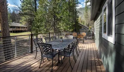 a patio with a table and chairs on a deck at Margaret's at The Redwoods in Wawona