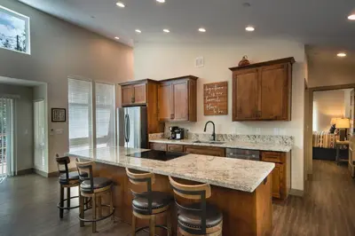 a kitchen with wooden cabinets and a island with bar stools at Spring Meadow Retreat in Wawona