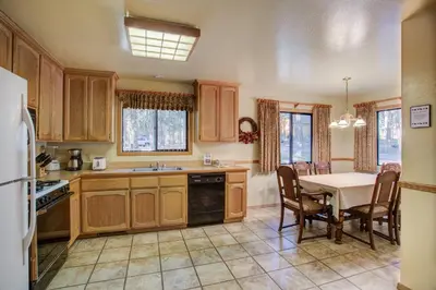 a kitchen with wooden cabinets and a table with a dining room at Cabin Twelve in Wawona