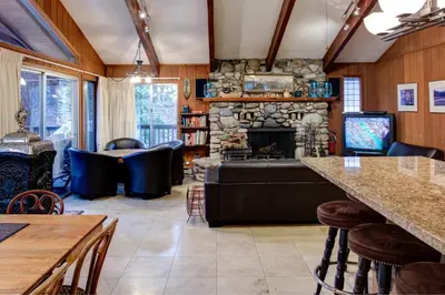 a living room with a stone fireplace and a tv at Star Gazers in Wawona