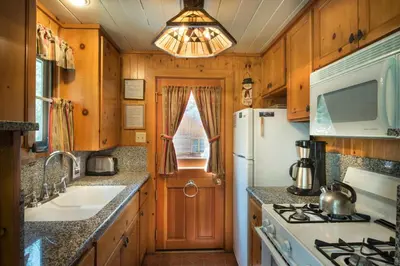 a kitchen with a white refrigerator and a sink at Chipmunk Hollow in Wawona