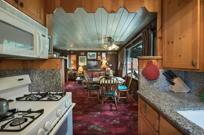 a kitchen with a stove and a dining room at Chipmunk Hollow in Wawona