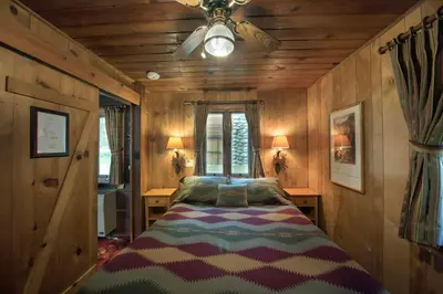 a bedroom with a bed with a ceiling fan at Chipmunk Hollow in Wawona