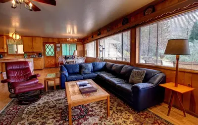 a living room with a blue couch and a table at Longview at The Redwoods in Wawona