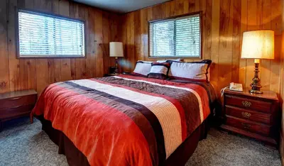 a bedroom with a large bed with wooden walls at Longview at The Redwoods in Wawona
