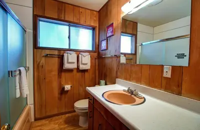 a bathroom with a sink and a toilet and a mirror at Longview at The Redwoods in Wawona