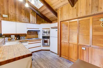 a kitchen with white appliances and wooden walls at Tyler's Timber Lodge in Wawona
