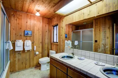 a wooden bathroom with a toilet and a sink at Tyler's Timber Lodge in Wawona