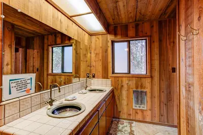 a bathroom with two sinks and wooden walls at Tyler's Timber Lodge in Wawona