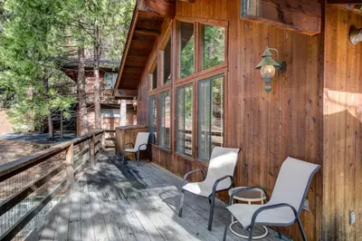 a porch of a cabin with chairs and windows at Tyler's Timber Lodge in Wawona