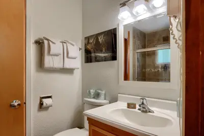 a bathroom with a sink and a toilet and a mirror at New Beginnings at The Redwoods Cabin in Wawona