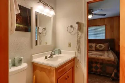a bathroom with a sink and a toilet and a mirror at New Beginnings at The Redwoods Cabin in Wawona