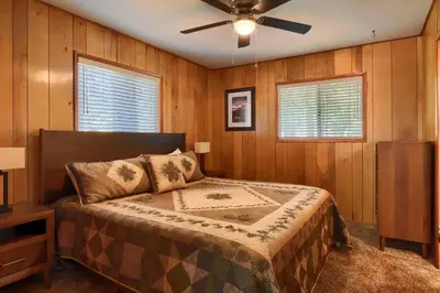 a bedroom with a bed and a ceiling fan at New Beginnings at The Redwoods Cabin in Wawona