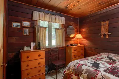 a bedroom with a bed and a dresser and a window at Le Fawn in Wawona