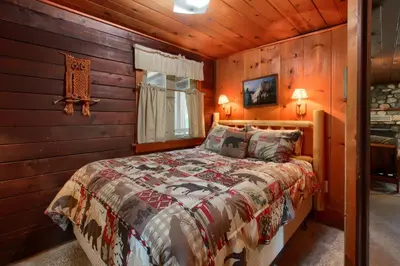 a bedroom with a bed in a log cabin at Le Fawn in Wawona