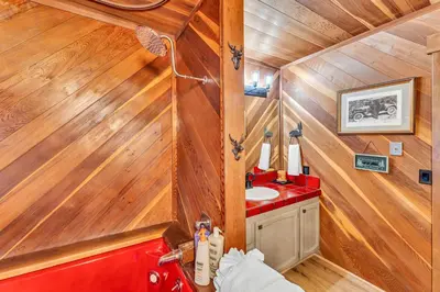 a bathroom with a red sink and wooden walls at Big Foots Den on the 10 Northstar Resort Truckee in Truckee