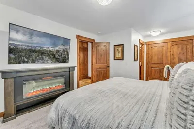 a bedroom with a bed and a fireplace at Big Foots Den on the 10 Northstar Resort Truckee in Truckee