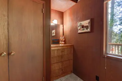a room with a wooden wall with a dresser and a window at Hiltbrand Hangout in Wawona