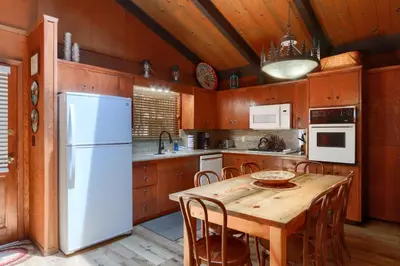 a kitchen with a table and a white refrigerator at Hiltbrand Hangout in Wawona