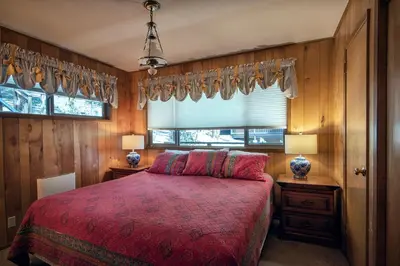 a bedroom with a red bed and a window at Yosemite Retreat in the Meadows in Wawona