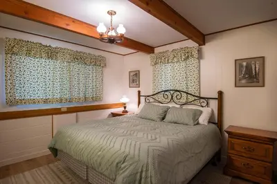 a bedroom with a bed and two windows at Yosemite Retreat in the Meadows in Wawona