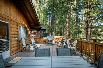 a deck with chairs and a grill on a house at Yosemite Retreat in the Meadows in Wawona