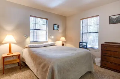 a bedroom with a bed and two windows at Wawona Retreat in Wawona