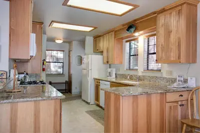 a kitchen with wooden cabinets and a white refrigerator at Wawona Retreat in Wawona