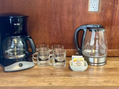 a coffee maker and glasses on a wooden table at Heart of the Meadow in Wawona