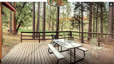a wooden deck with a table and chairs on it at Heart of the Meadow in Wawona