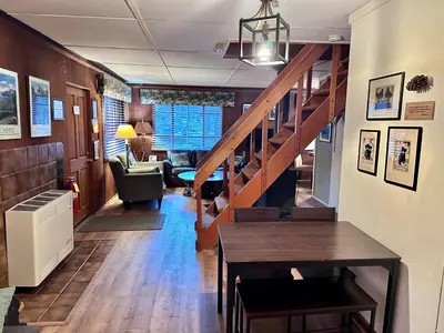 a hallway with a staircase and a living room at Heart of the Meadow in Wawona