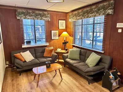 a living room with two couches and a table at Heart of the Meadow in Wawona