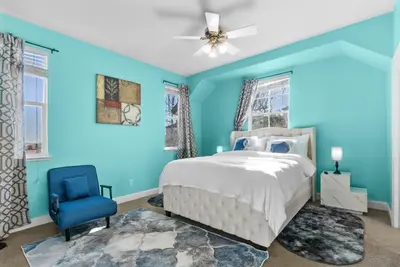 a blue bedroom with a bed and a blue chair at Game Lovers Retreat, spacious 4000 sqft Getaway in El Dorado Hills