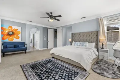 a bedroom with a large bed and a blue couch at Game Lovers Retreat, spacious 4000 sqft Getaway in El Dorado Hills