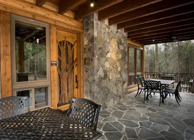 a screened in porch with a table and chairs at Rustic Retreat in Wawona