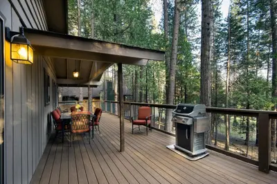 a deck with a table and chairs and a grill at We-Dunn-It in Wawona