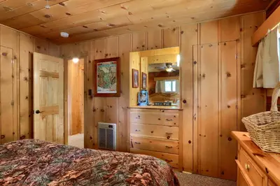 a bedroom with wooden walls and a bed in a room at Bradley's Cabin in Wawona