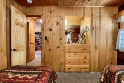 a bedroom with wooden walls and a closet with a dresser at Bradley's Cabin in Wawona