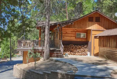 a log home with a tree in front of it at Bradley's Cabin in Wawona