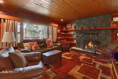 a living room with a couch and a fireplace at Bradley's Cabin in Wawona