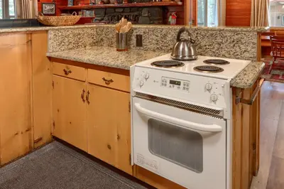 a kitchen with a stove with a tea kettle on it at Bradley's Cabin in Wawona