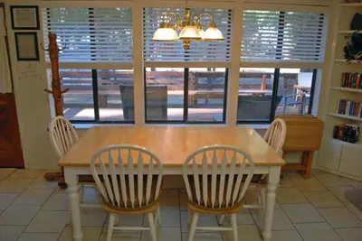 a dining room table with four chairs and a window at Big Cedar in Wawona