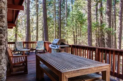 a deck with a grill and a table and chairs at Robin's Nest in Wawona