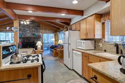 a kitchen with wooden cabinets and a white refrigerator at Robin's Nest in Wawona