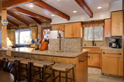 a kitchen with wooden cabinets and a large island with bar stools at Robin's Nest in Wawona