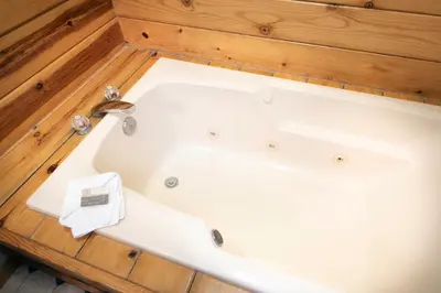 a white bath tub in a room with wooden floors at Wawona Cabin in Wawona
