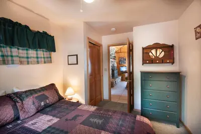 a bedroom with a bed and a dresser and a mirror at Wawona Cabin in Wawona